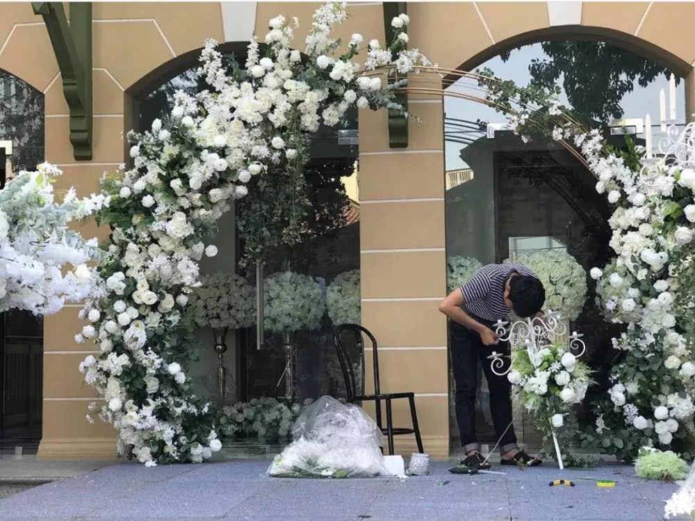 Grand ballroom wedding setup with white faux flower wall and candles